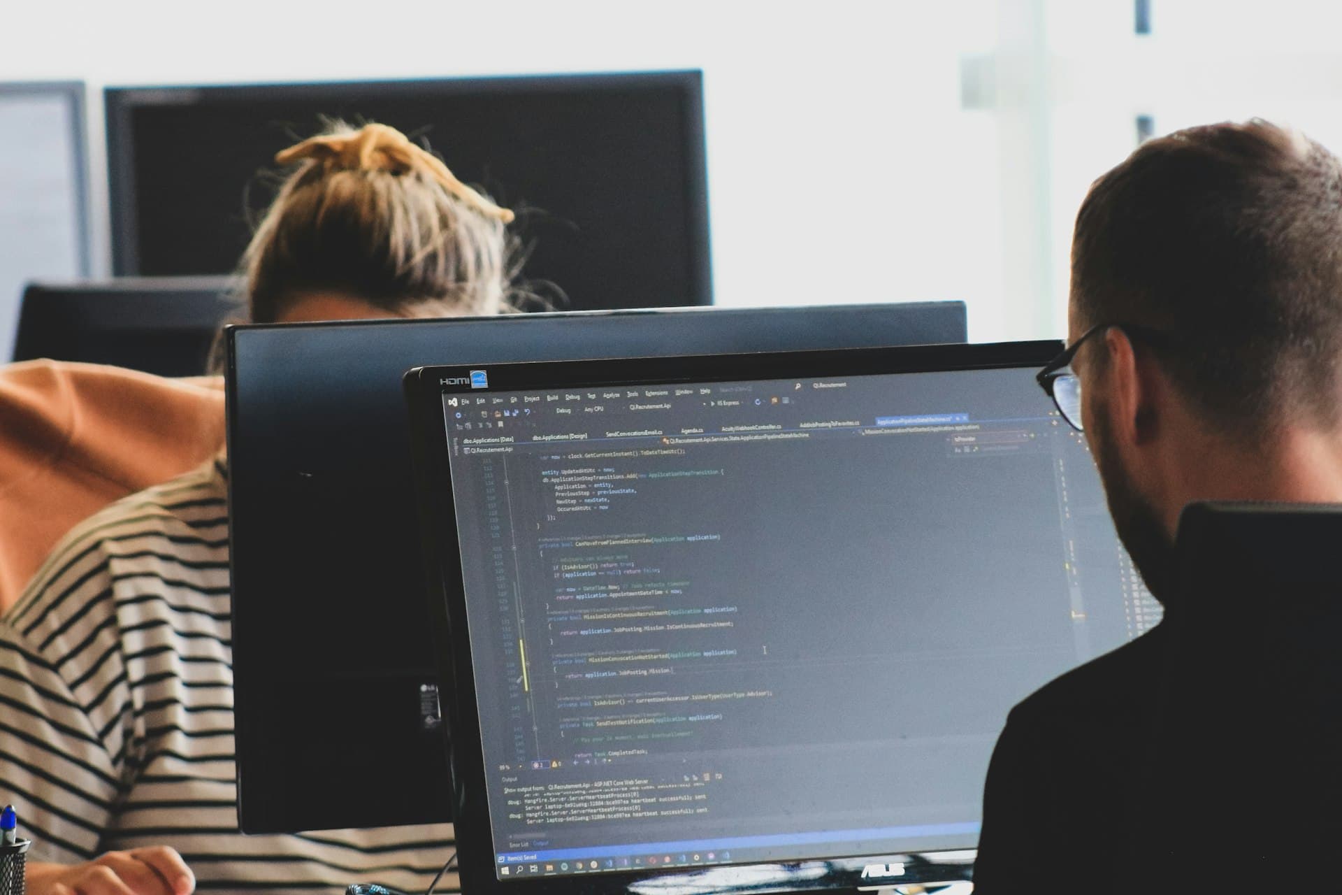 Two engineers reviewing code together at a monitor